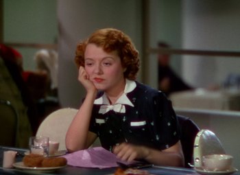Movie still from “A Star Is Born” (1937), directed by Victor Fleming – A woman sitting at a table with a cup of coffee; Close Up shot, High angle