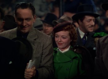 Movie still from “A Star Is Born” (1937), directed by Victor Fleming – A man and a woman are standing in a crowd; Medium shot, Low angle