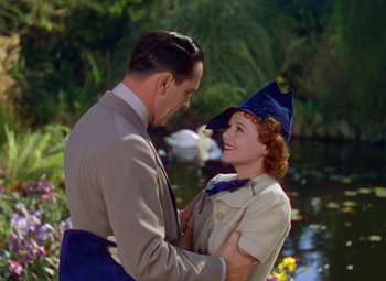 Movie still from “A Star Is Born” (1937), directed by Victor Fleming – A man and a woman are standing next to a body of water; Medium shot, High angle