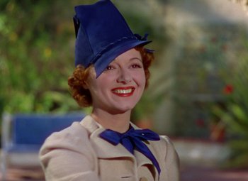 Movie still from “A Star Is Born” (1937), directed by Victor Fleming – A woman wearing a blue hat and a bow tie; Close Up shot, Low angle