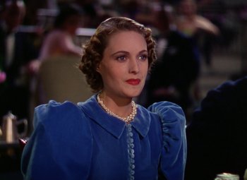 Movie still from “A Star Is Born” (1937), directed by Victor Fleming – A woman in a blue dress with a pearl necklace; Close Up shot, Over the shoulder angle
