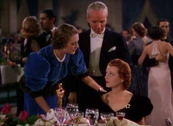 Movie still from “A Star Is Born” (1937), directed by Victor Fleming – Two women and an older man at a formal event; Medium shot, Low angle