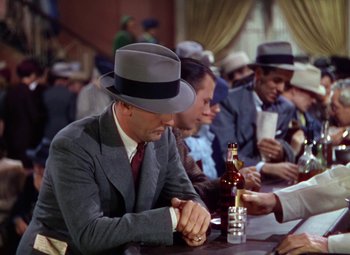 Movie still from “A Star Is Born” (1937), directed by Victor Fleming – A group of men sitting at a table drinking beer; Medium shot, High angle