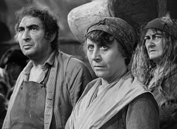 Movie still from “A Tale of Two Cities” (1935), directed by Jack Conway – A black and white photo of a woman and two men; Medium shot, High angle