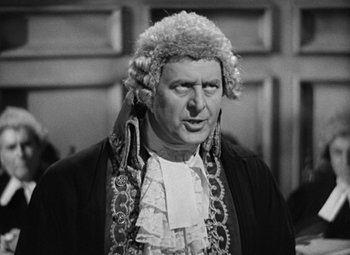 Movie still from “A Tale of Two Cities” (1935), directed by Jack Conway – An older man in a judge's wig and gown; Medium shot, Over the shoulder angle