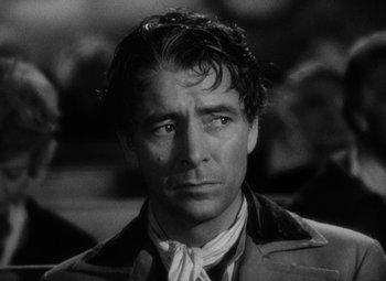 Movie still from “A Tale of Two Cities” (1935), directed by Jack Conway – Black and white photograph of a man in a trench coat; Close Up shot, Over the shoulder angle