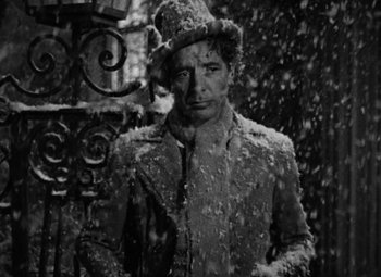 Movie still from “A Tale of Two Cities” (1935), directed by Jack Conway – A black and white photo of a man in a coat and hat; Medium shot, High angle