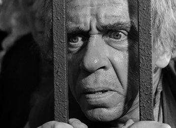 Movie still from “A Tale of Two Cities” (1935), directed by Jack Conway – An old man is looking through the bars of a jail cell; Close Up shot, Low angle