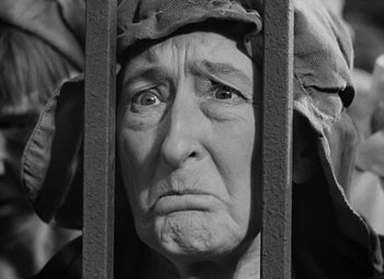 Movie still from “A Tale of Two Cities” (1935), directed by Jack Conway – An old woman is looking through a fence; Close Up shot, Low angle
