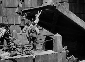 Movie still from “A Tale of Two Cities” (1935), directed by Jack Conway – A group of people climbing up a wooden structure; Wide shot, High angle
