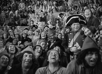 Movie still from “A Tale of Two Cities” (1935), directed by Jack Conway – A group of people that are sitting in a stadium; Wide shot, High angle