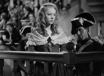 Movie still from “A Tale of Two Cities” (1935), directed by Jack Conway – A woman in a dress and a man in a hat; Medium shot, Over the shoulder angle