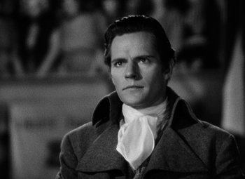 Movie still from “A Tale of Two Cities” (1935), directed by Jack Conway – A black and white photo of a man in a coat and tie; Close Up shot, Over the shoulder angle