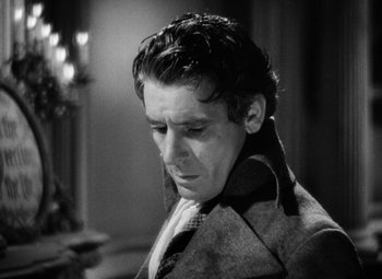 Movie still from “A Tale of Two Cities” (1935), directed by Jack Conway – A black and white photo of a man in a suit and tie; Close Up shot, Over the shoulder angle