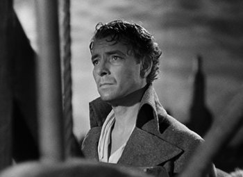 Movie still from “A Tale of Two Cities” (1935), directed by Jack Conway – Black and white photograph of a man in a trench coat; Close Up shot, Low angle