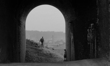 A man standing on a dirt hill with a child