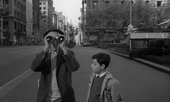 Movie still from “A Thousand Clowns” (1965), directed by Fred Coe – A man taking a picture of a boy with a camera; Medium shot, Over the shoulder angle