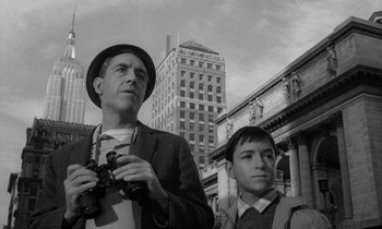 Movie still from “A Thousand Clowns” (1965), directed by Fred Coe – A man and a young boy are standing in front of a building; Medium shot, Low angle