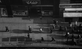 Movie still from “A Thousand Clowns” (1965), directed by Fred Coe – A black and white photo of people walking down a street; Extreme Wide shot, Overhead angle