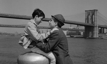 Movie still from “A Thousand Clowns” (1965), directed by Fred Coe – A man and a boy sitting next to each other on the water; Medium shot, High angle