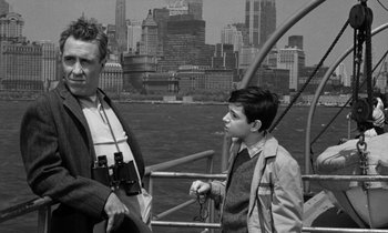Movie still from “A Thousand Clowns” (1965), directed by Fred Coe – A man and a boy standing next to each other on a boat; Medium shot, Over the shoulder angle