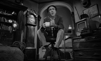 Movie still from “A Thousand Clowns” (1965), directed by Fred Coe – A man sitting on a stool holding a cup; Medium shot, Low angle