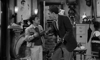 Movie still from “A Thousand Clowns” (1965), directed by Fred Coe – Two young men are playing the ukulele together; Medium shot, High angle