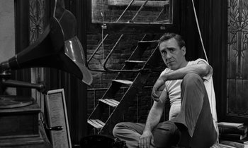 Movie still from “A Thousand Clowns” (1965), directed by Fred Coe – A black and white photo of a man sitting on the ground; Medium shot, Low angle