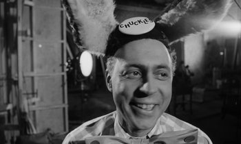Movie still from “A Thousand Clowns” (1965), directed by Fred Coe – A man wearing a hat that says chuckies; Close Up shot, Over the shoulder angle