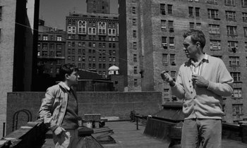 Movie still from “A Thousand Clowns” (1965), directed by Fred Coe – Two people standing on a roof top in a city; Medium shot, Over the shoulder angle