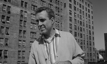 Movie still from “A Thousand Clowns” (1965), directed by Fred Coe – A black and white photo of a man standing in front of a building; Close Up shot, Low angle