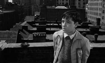 Movie still from “A Thousand Clowns” (1965), directed by Fred Coe – A young man standing on a rooftop looking off into the distance; Medium shot, High angle