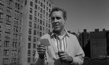Movie still from “A Thousand Clowns” (1965), directed by Fred Coe – A black and white photo of a man holding a piece of paper; Medium shot, Low angle