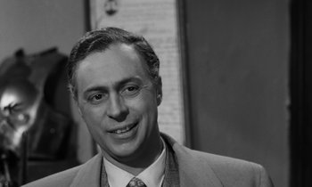 Movie still from “A Thousand Clowns” (1965), directed by Fred Coe – Black and white photograph of a man in a suit and tie; Close Up shot, Low angle