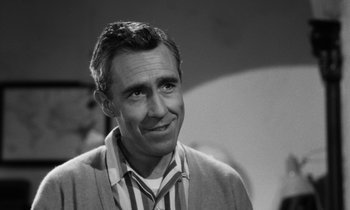 Movie still from “A Thousand Clowns” (1965), directed by Fred Coe – Black and white photograph of a man smiling for the camera; Close Up shot, Over the shoulder angle