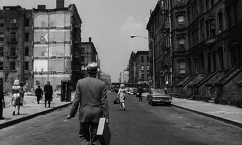 Movie still from “A Thousand Clowns” (1965), directed by Fred Coe – An old black and white photo of people walking down a street; Wide shot, Over the shoulder angle