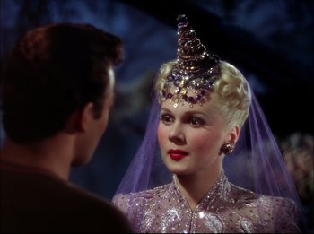 A man and a woman wearing a purple dress and a veil