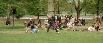 Movie still from “A Touch of Class” (1973), directed by Melvin Frank – A group of people sitting and standing in the grass; Wide shot, High angle