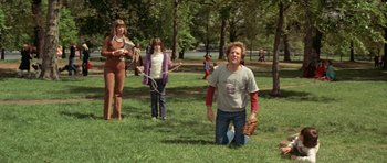 Movie still from “A Touch of Class” (1973), directed by Melvin Frank – A group of people standing in the grass; Wide shot, Low angle