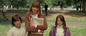 A woman and a girl are standing in a park