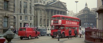 Movie still from “A Touch of Class” (1973), directed by Melvin Frank – A red double decker bus driving down a street; Extreme Wide shot, Low angle