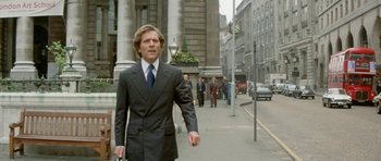 Movie still from “A Touch of Class” (1973), directed by Melvin Frank – A man walking down the street in a business suit; Medium shot, Low angle