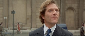 Movie still from “A Touch of Class” (1973), directed by Melvin Frank – A person wearing a suit and tie; Close Up shot, Low angle