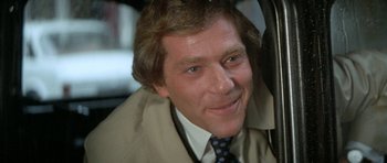 Movie still from “A Touch of Class” (1973), directed by Melvin Frank – A person wearing a suit and tie; Close Up shot, Over the shoulder angle