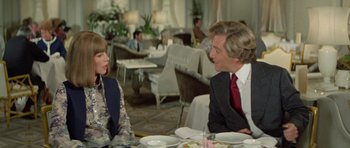 Movie still from “A Touch of Class” (1973), directed by Melvin Frank – A man and a woman sitting at a table in a restaurant; Medium shot, Over the shoulder angle