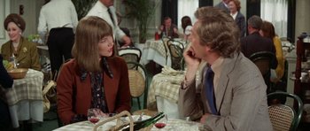 Movie still from “A Touch of Class” (1973), directed by Melvin Frank – A group of people sitting at a table in a restaurant; Medium shot, Over the shoulder angle