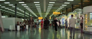 Movie still from “A Touch of Class” (1973), directed by Melvin Frank – A group of people walking in an airport terminal; Wide shot, Low angle