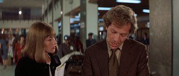 Movie still from “A Touch of Class” (1973), directed by Melvin Frank – A man in a suit and tie next to a woman in a suit; Close Up shot, Over the shoulder angle