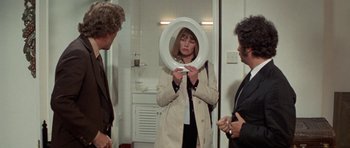 Movie still from “A Touch of Class” (1973), directed by Melvin Frank – A group of people standing in a room; Medium shot, Over the shoulder angle