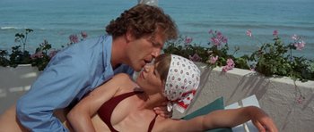 Movie still from “A Touch of Class” (1973), directed by Melvin Frank – A man and a woman kissing on the beach; Close Up shot, Low angle